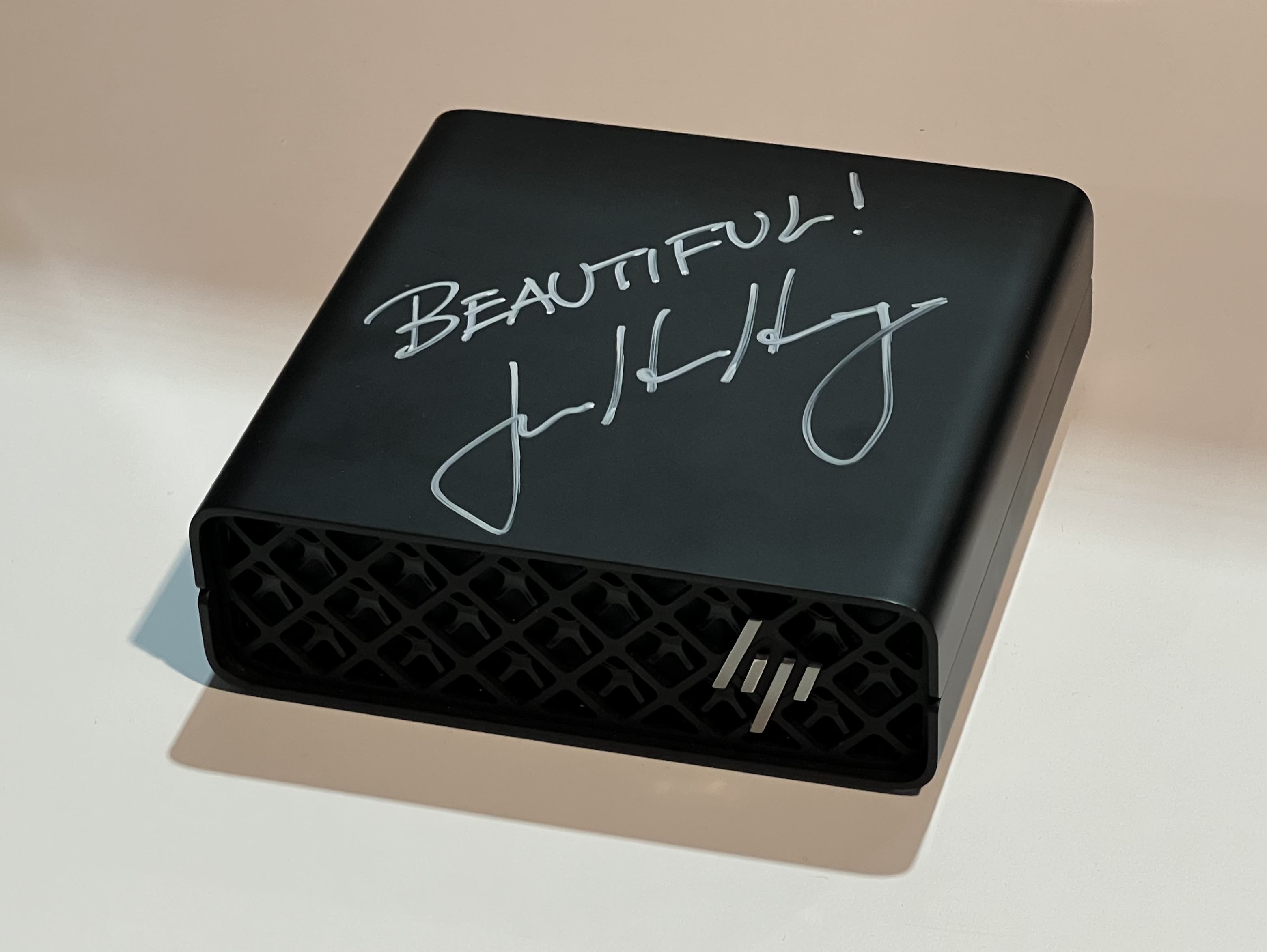 HP ZGX Nano AI Station (G1n), compact black mesh-front cube with HP logo and a silver BEAUTIFUL! signature on the lid.